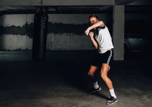 Bonito boxeador jovem durante exercícios de boxe — Fotografia de Stock