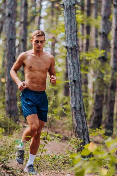 Young sportive man exercise running outdoors keeping fit at moun