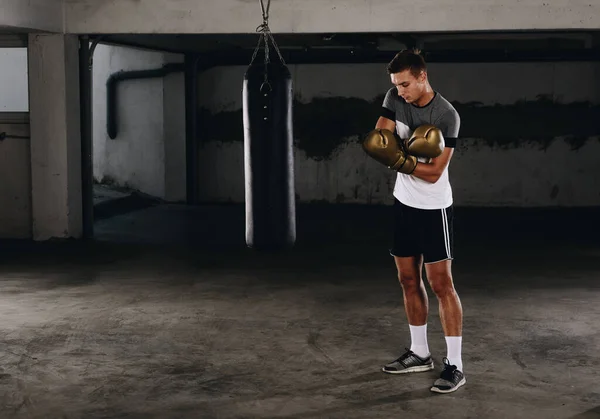 Junger sportlicher kaukasischer Boxer zieht Handschuhe an — Stockfoto