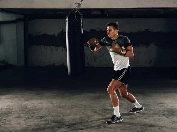 Junger kaukasischer Boxer beim Boxsack-Training in seiner Heimat — Stockfoto