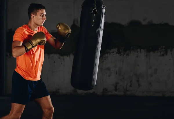 Mladý kavkazský boxer trénink sám s boxovací pytel ve zdraví — Stock fotografie