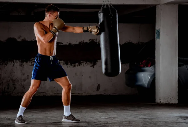 Boxeador lanza golpes en el gimnasio mientras entrena — Foto de Stock