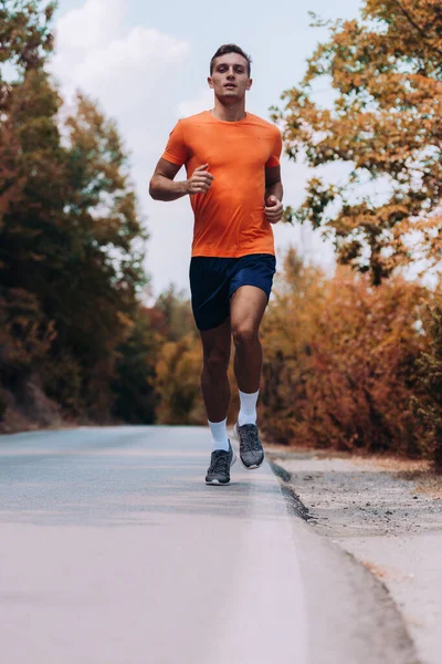 Man joger hardlopen in de bergen onder zonlicht — Stockfoto