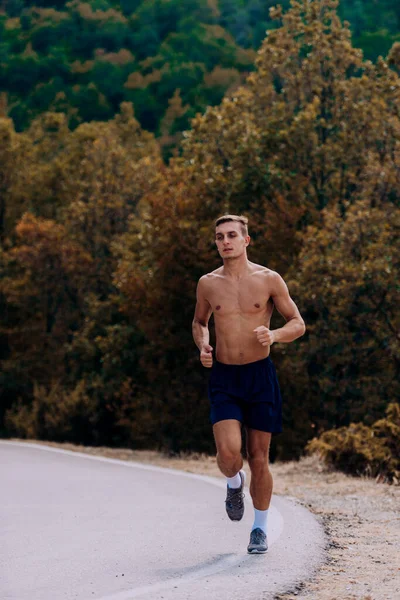 Full body portret van een fitte man loopt buiten op een berg r — Stockfoto