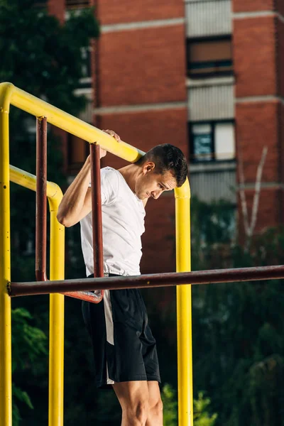 Hombre fuerte realizando pull ups en un bar —  Fotos de Stock