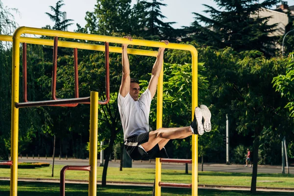 Strong young muscular man doing pull-up exercise at the outdoors — Stock Photo, Image