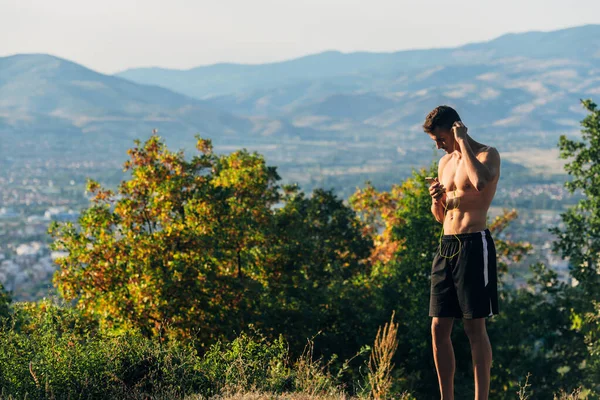 Mannelijke loper parepre muziek op zijn apparaat en voor te bereiden op joggen — Stockfoto