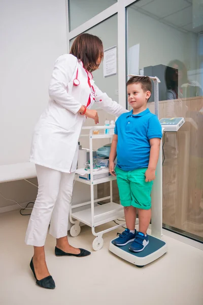 Médico femenino midiendo la altura del niño en una clínica (h —  Fotos de Stock