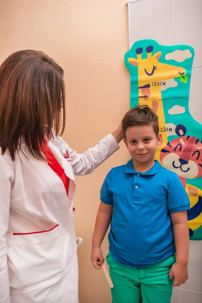 Pediatra hembra comprobar es la garganta y la boca de un cute joven. —  Fotos de Stock