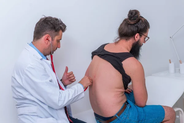 El médico masculino comprueba que es su paciente hipnótico con un estetoscopio.. —  Fotos de Stock