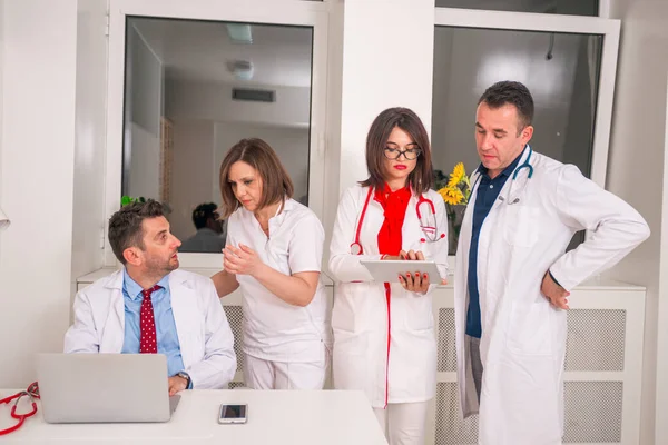Grupo de médicos de pie y discutir mientras se mira a un —  Fotos de Stock