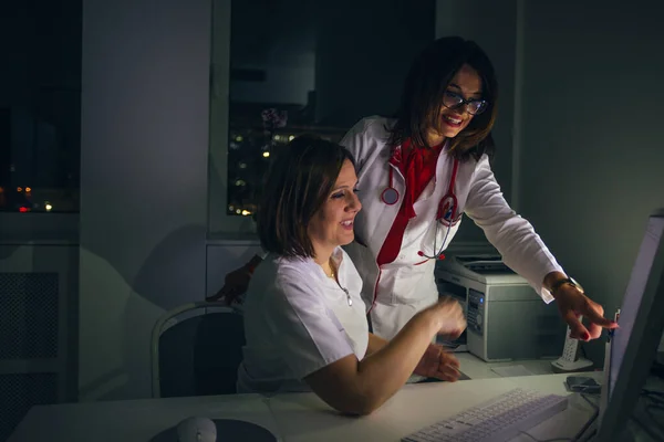 Médicos femeninos (médicos) trabajan en una PC tarde en la noche . —  Fotos de Stock