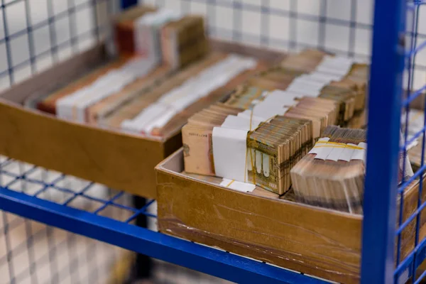 Pacotes de dinheiro em caixas em gaiola de metal seguro — Fotografia de Stock