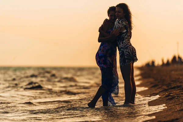 Günbatımı sahilde iki uygun kadın silüeti — Stok fotoğraf
