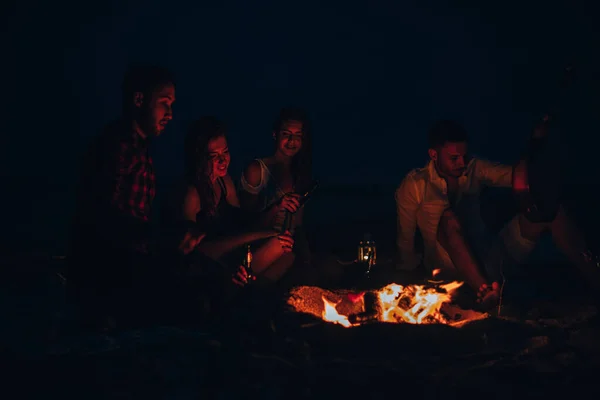 Freunde genießen Musik am Lagerfeuer in der Nacht — Stockfoto