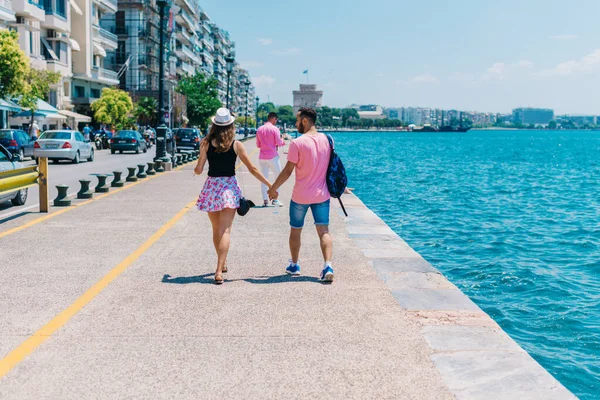 Kız hol iken bir Boardwalk üzerinde deniz tarafından yürüyüş sevimli çift — Stok fotoğraf