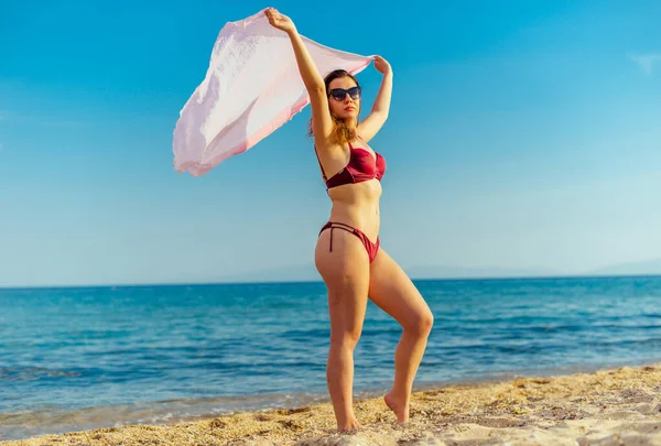 Belle jeune femme posant en bikini rouge près de la mer — Photo