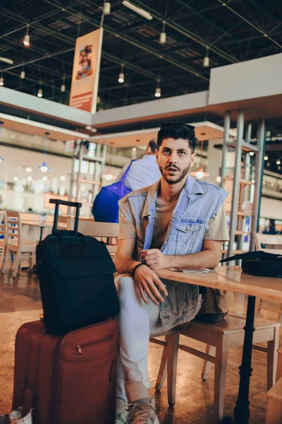 Hombre sentado en la sala del aeropuerto, esperando el vuelo —  Fotos de Stock