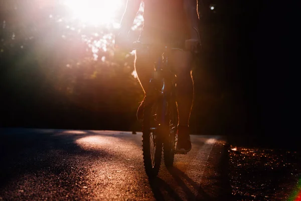 Erkek bisikletçi gün batımında bisikletiyle derin bir yolda — Stok fotoğraf