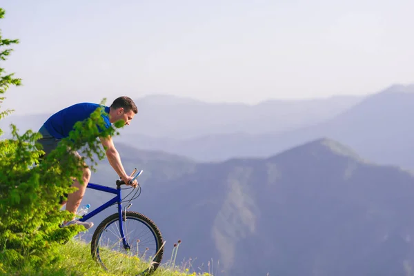 FIt male Cyclist is speeding up his bicycle downhill while enjoy — Stock Photo, Image