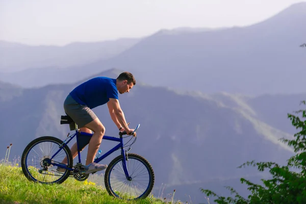 健康的男性骑自行车者一边骑自行车一边慢慢下山 — 图库照片