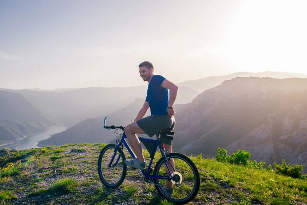 Abenteuerlustiger Radfahrer mit seinem Mountainbike am Waldrand — Stockfoto