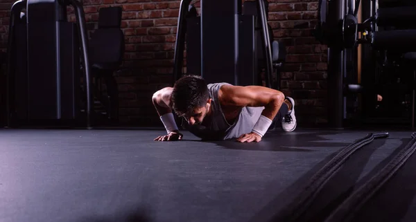 Hombre activo con ajuste muscular cuerpo haciendo push ups —  Fotos de Stock