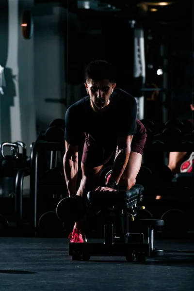 Spor salonunda zayıf kaslı adam ağırlık kaldırıyor. — Stok fotoğraf