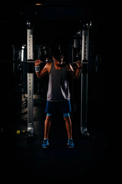 Zayıf kaslı adam spor salonunda ağırlık çalışıyor. — Stok fotoğraf