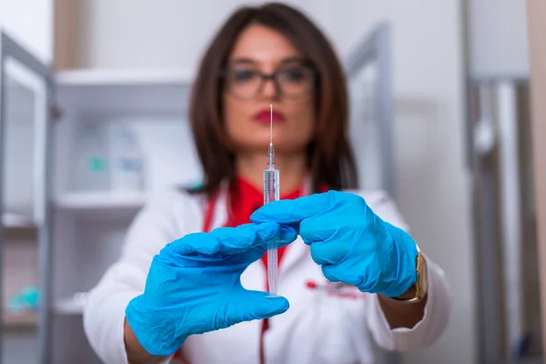 Chiudere un medico (infermiere) di sesso femminile con in mano una siringa mentre — Foto Stock