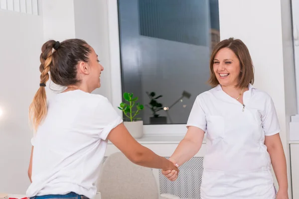 Médico femenino revisando la boca de una adolescente con un depresor . —  Fotos de Stock