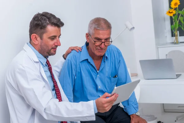 Ein Arzt spricht mit einem älteren (alten) Patienten im Büro und — Stockfoto