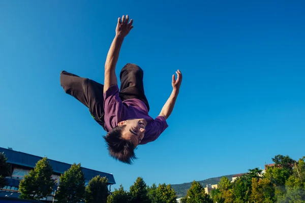 Młody człowiek wykonuje salto w bok — Zdjęcie stockowe