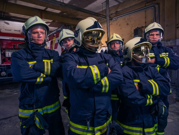 Portret van de groep brandweerlieden in de voorkant van de brandweerwagen in de — Stockfoto