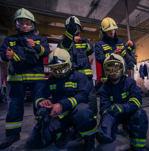 Портрет группы пожарных перед пожарной машиной внутри здания — стоковое фото