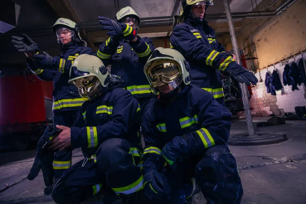 Retrato de bomberos de grupo frente al camión de bomberos dentro del interior del interior. —  Fotos de Stock