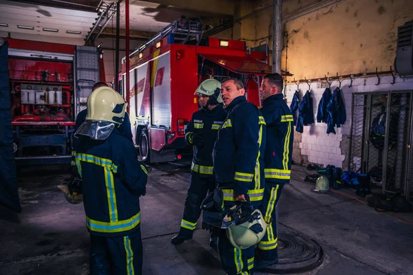 Bomberos que preparan su uniforme y el camión de bomberos de la ba — Foto de Stock
