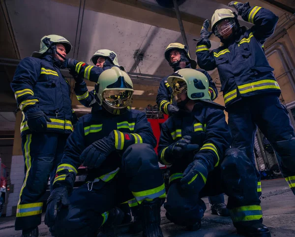 Retrato de bomberos de grupo frente al camión de bomberos dentro del interior del interior. —  Fotos de Stock