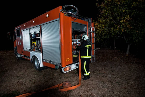 Equipe Bombeiros Plena Engrenagem Operando Uma Mangueira Água Uma Área — Fotografia de Stock