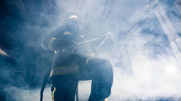 Retrato de una mujer bombero mientras sostiene un hacha y el desgaste —  Fotos de Stock