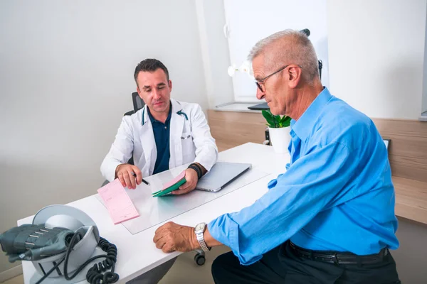 Kaukasischer Arzt Mittleren Alters Erklärt Seinem Älteren Patienten Seine Blutdruckwerte — Stockfoto