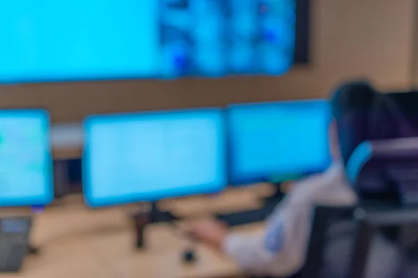 坐在主控制室的警卫在计算机上工作的模糊照片 — 图库照片