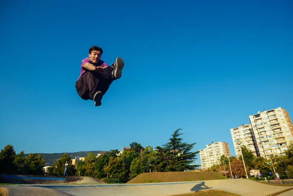 Hombre Atlético Joven Realizando Movimiento Patada Voladora Skatepark — Foto de Stock