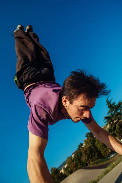 Akrobatikus Férfi Kiegyensúlyozása Közben Kézenállás Beton Padlón Skatepark — Stock Fotó