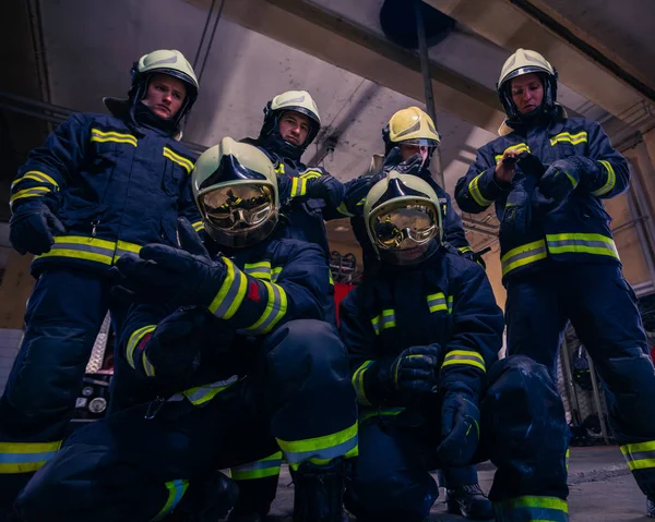 Retrato de bomberos de grupo frente al camión de bomberos dentro del interior del interior. —  Fotos de Stock