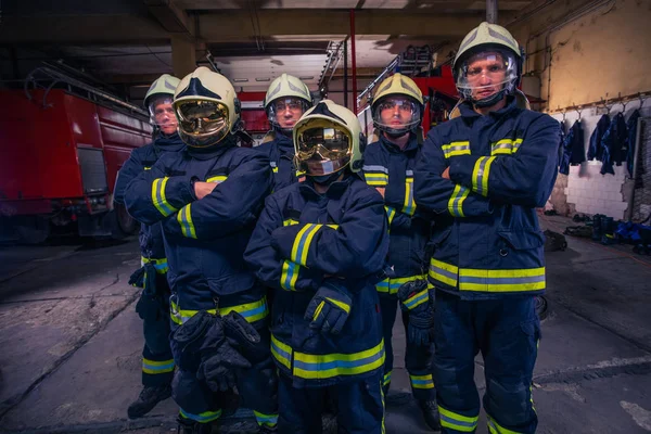 Portrait of group firefighters in front of firetruck inside the