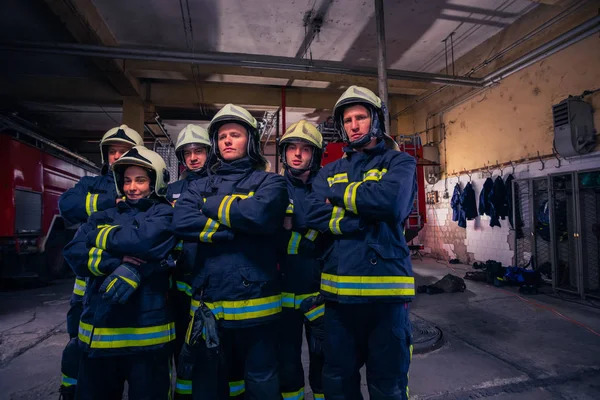 Portrait of group firefighters in front of firetruck inside the — Stock Photo, Image