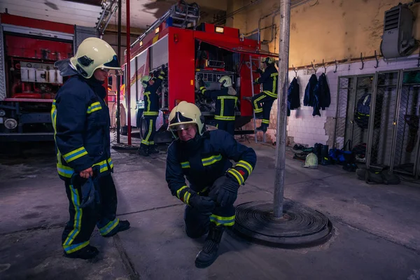 Bomberos que preparan su uniforme y el camión de bomberos de la ba —  Fotos de Stock