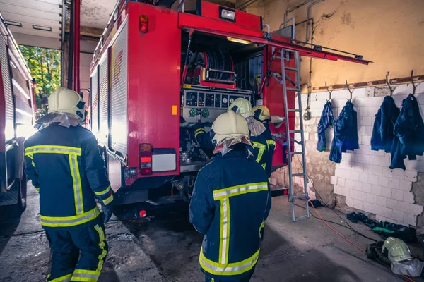 消防士のグループは消防署内の消防車の圧力と水を準備し 検査する — ストック写真