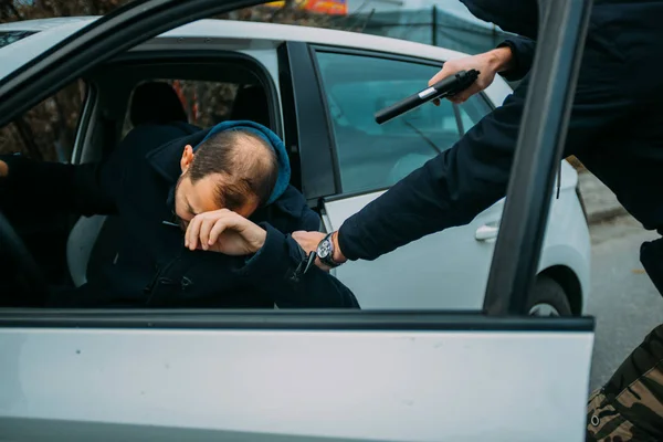 Gangster with a gun trying to rob a guy which is sitting in his — Stock Photo, Image